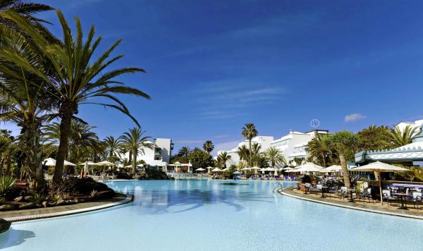 Blick auf den pool mit Liegebereich und Sonnenschirmen