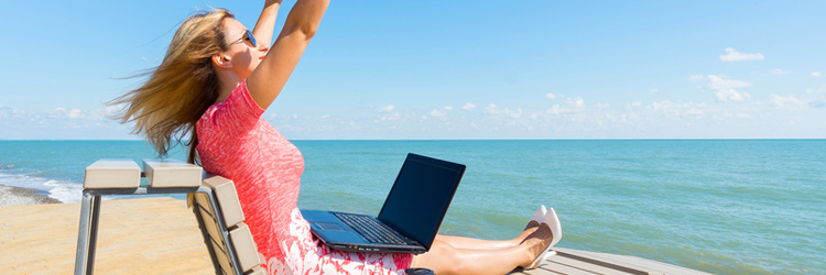 Frau mit Laptop am Strand